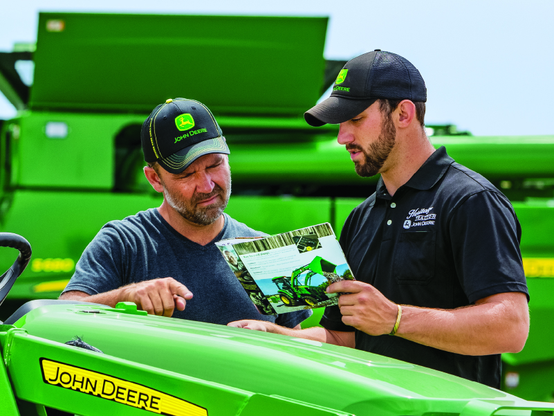 Global Equipment Salesman with customer discussing tractor